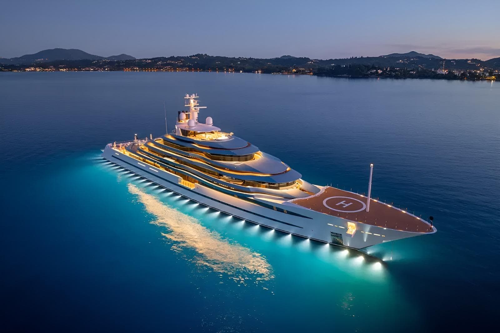 Superyacht at anchor at dusk with underwater lighting and helipad, listed for sale to a global audience