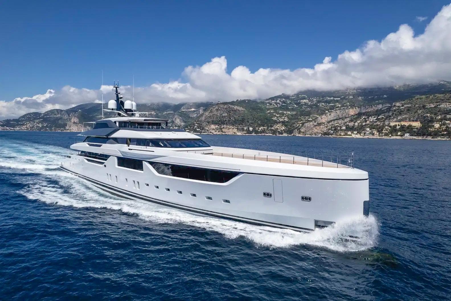 Superyacht underway along the Mediterranean coastline, professionally presented for sale to a global audience